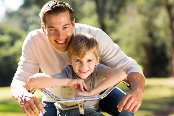 Happy father and son on bike