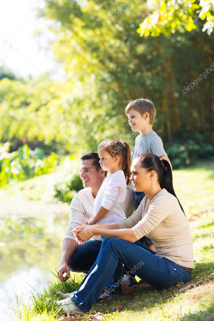Happy family of four by pond