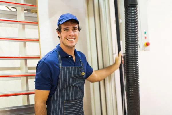 Werknemer permanent in de buurt van snijmachine — Stockfoto