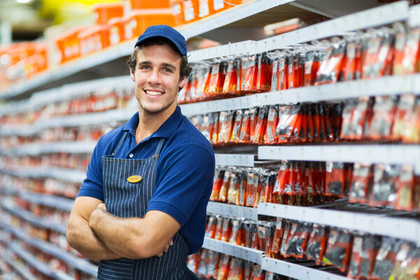 Salesman standing next to fasteners shelf