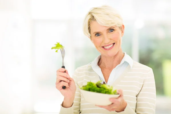 Mulher de meia idade comendo salada — Fotografia de Stock