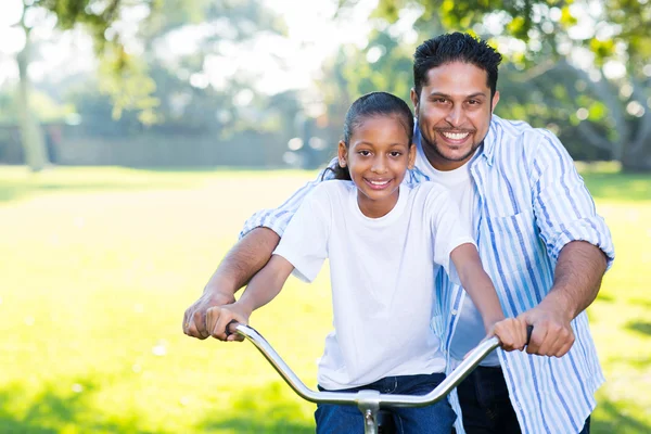 Father helping daughter ride bike — Stock Photo, Image