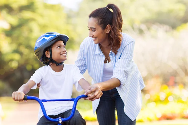 Mãe ajuda filho andar de bicicleta — Fotografia de Stock