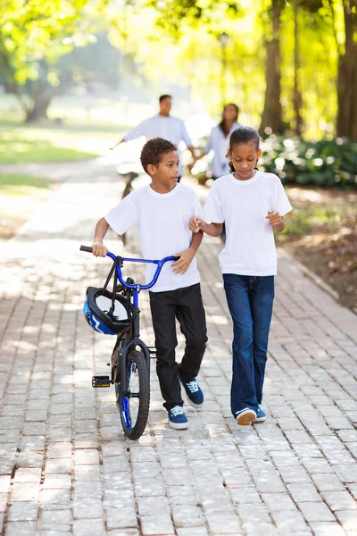 Niños caminando con sus padres detrás — Foto de Stock