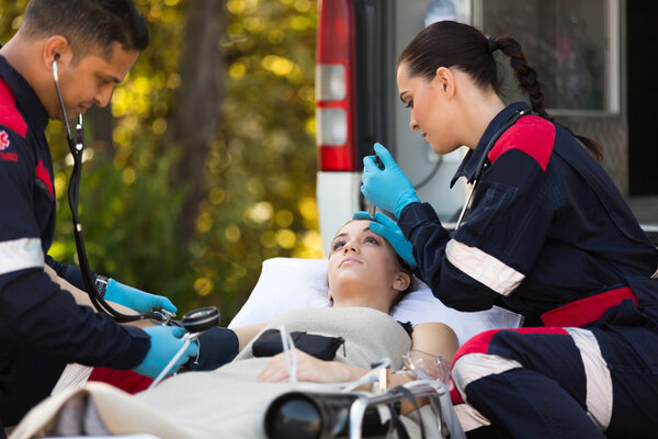 Paramedic team examining patient