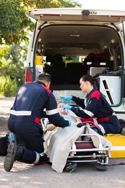 Paramedic putting oxygen mask on patient — Stock Photo, Image