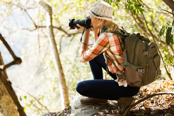 Jovem mulher tirar fotos na floresta — Fotografia de Stock