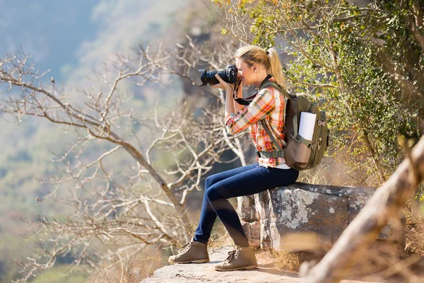 Mulher tirando fotos pela borda do penhasco — Fotografia de Stock