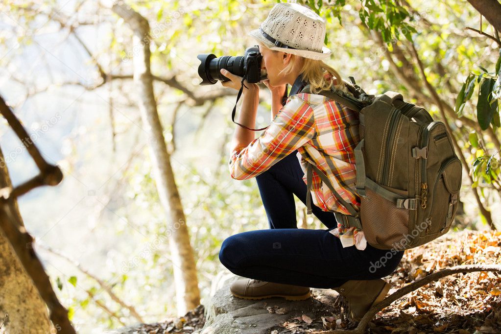 young woman taking photos in forest