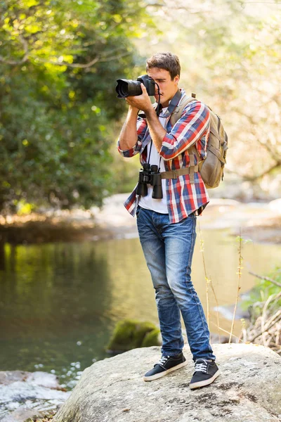 Man taking photos in mountain valley — Stock Photo, Image