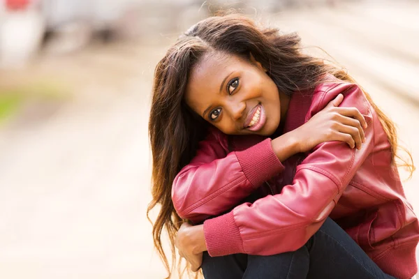 Black woman sitting outdoors — Stock Photo, Image