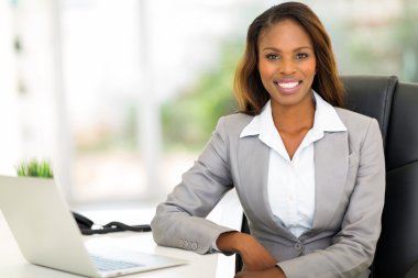 young afro american businesswoman sitting in office clipart