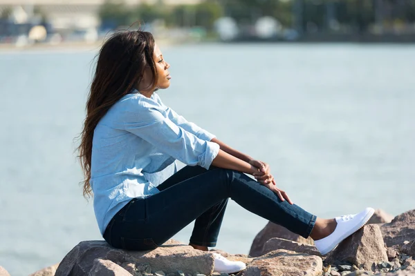 Afrikansk kvinna sitter vid hamnen — Stockfoto