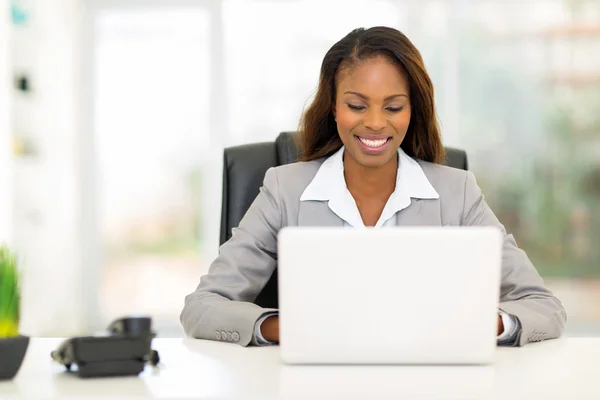 Afro americana empresária usando computador portátil — Fotografia de Stock