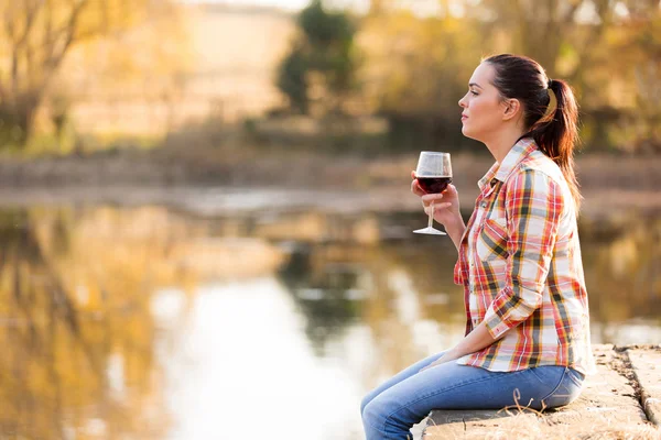 Jonge vrouw met glas wijn op pier — Stockfoto