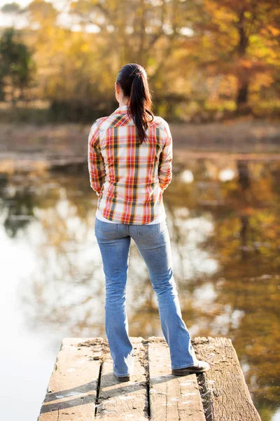 Rückansicht einer jungen Frau, die auf der Seebrücke steht — Stockfoto