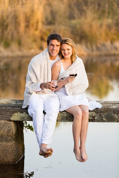 Pareja sentada en el muelle y bebiendo vino —  Fotos de Stock