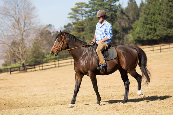 Ung man rider en häst — Stockfoto