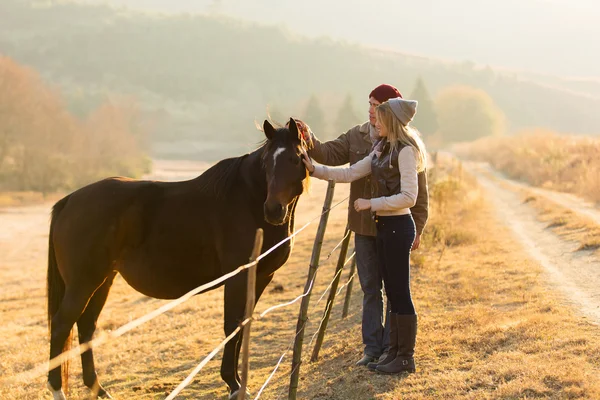 Pareja acariciando caballo — Foto de Stock