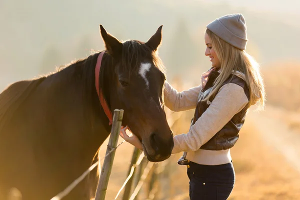 Femme caressant cheval dans la ferme — Photo