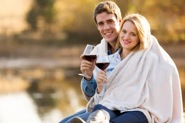 Молодая пара обнимается на открытом воздухе с бокалом вина Стоковое Изображение