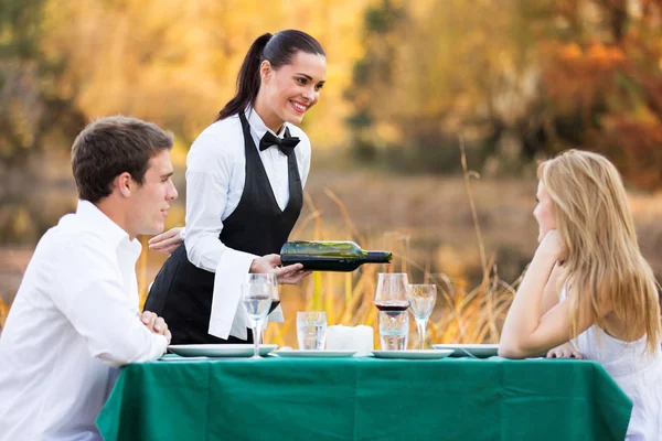 Официантка наливает вино для романтической пары Лицензионные Стоковые Фото