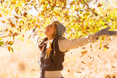 mutlu genç kadına düşen sonbahar yaprakları