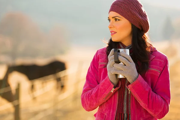 Στοχαστικό γυναίκα σε χειμωνιάτικα ρούχα κρατώντας ζεστό ρόφημα — Φωτογραφία Αρχείου