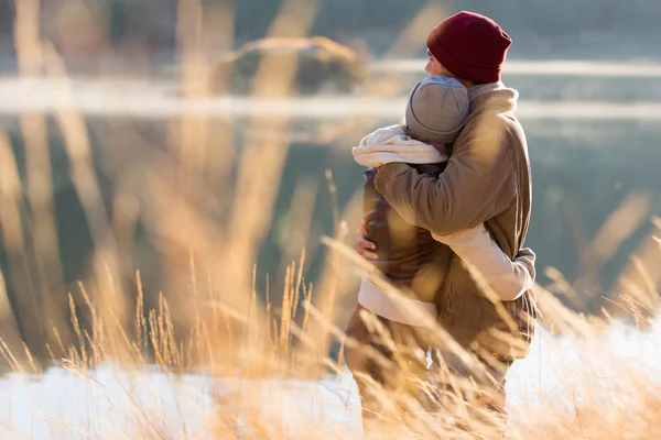 Rückansicht eines jungen Paares, das sich im Winter umarmt — Stockfoto