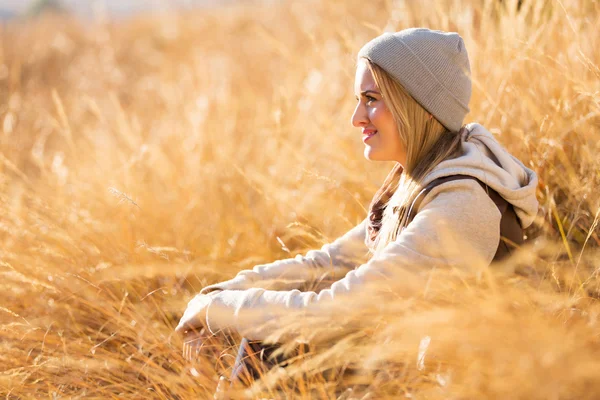 Vrouw zitten op herfst gras — Stockfoto