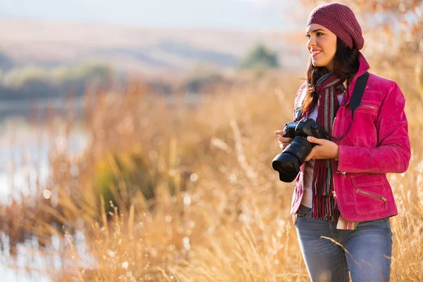 Молодая женщина-фотограф держит камеру на улице — стоковое фото