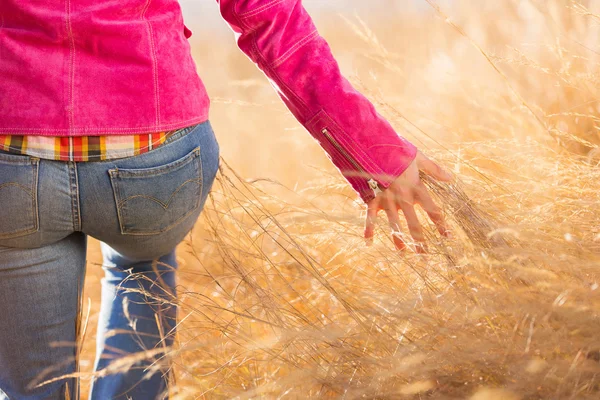 Giovane donna che cammina nel campo autunnale — Foto Stock