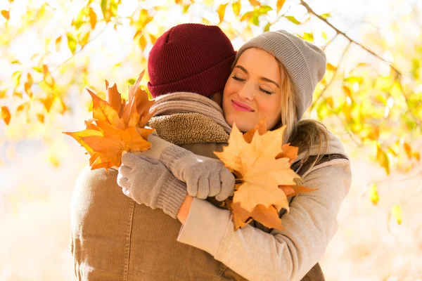 Jonge vrouw haar vriendje knuffelen in de herfst — Stockfoto