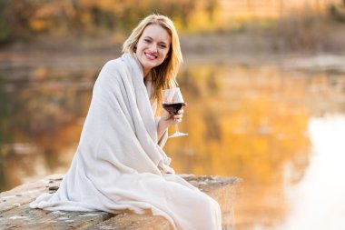 Günbatımında gülümseyen kadın içki kırmızı şarap