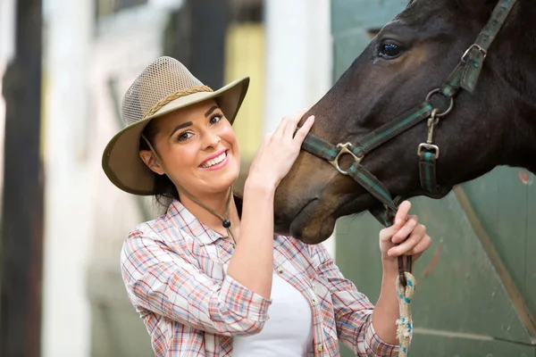 Gelukkig veedrijfster en haar paard in stal — Stockfoto