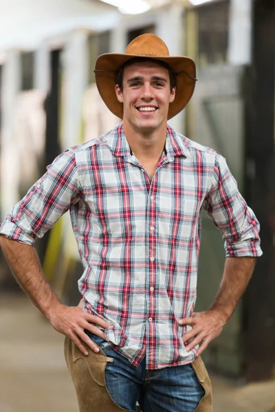 Cowboy americano em pé em estábulos — Fotografia de Stock