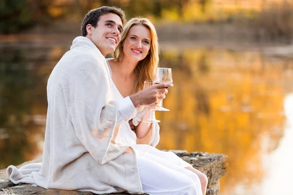 Прекрасная пара, пьющая вино у озера Лицензионные Стоковые Изображения