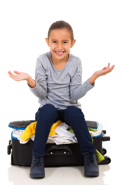 Girl sitting on overfilled suitcase — Stock Photo, Image