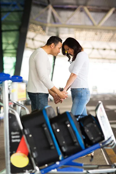 Мужчина утешает девушку в аэропорту — стоковое фото