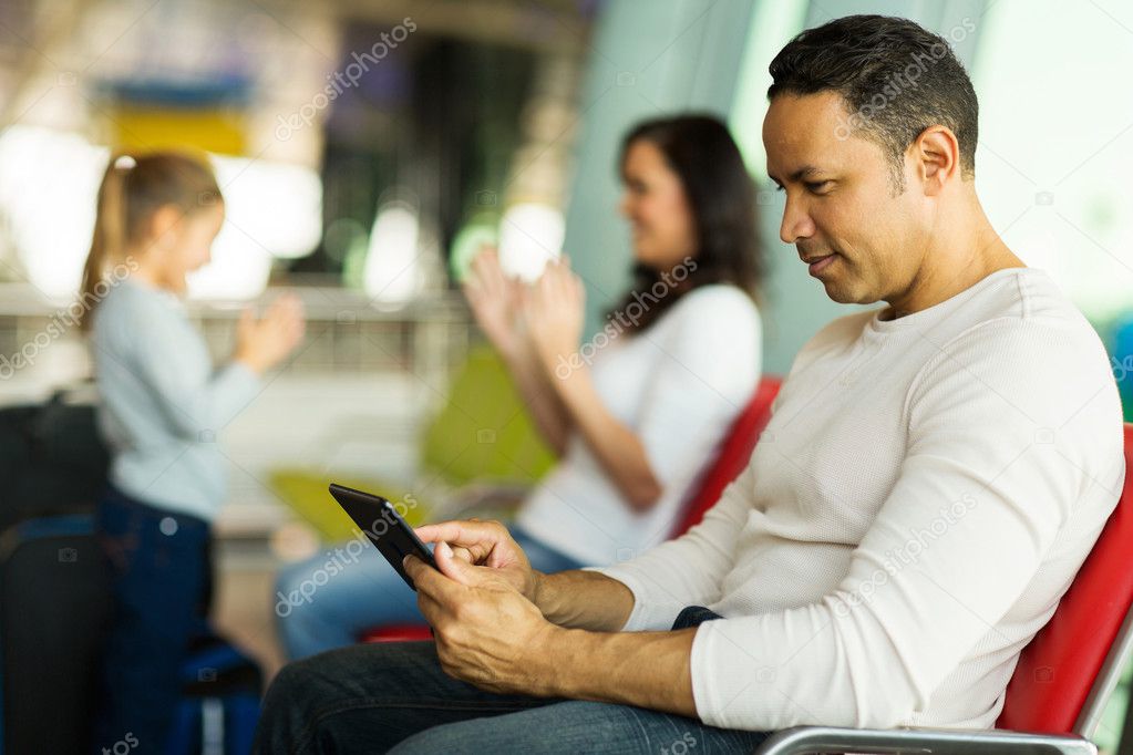 Man at airport using tablet