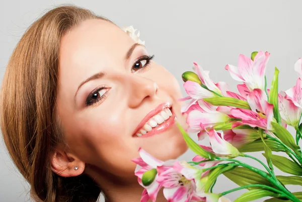 Jovem feliz bonita segurando flores de primavera rosa — Fotografia de Stock