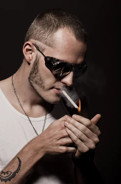 Young man lights a cigarette — Stock Photo, Image