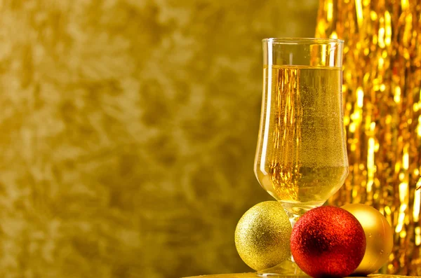 One glass of champagne with a Christmas decor in the background — Stock Photo, Image