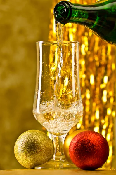 One glass of champagne with a Christmas decor in the background Royalty Free Stock Images