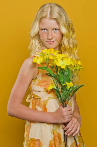 Blondes Mädchen, das mit gefalteten Händen in einem Garten steht und anschaut — Stockfoto