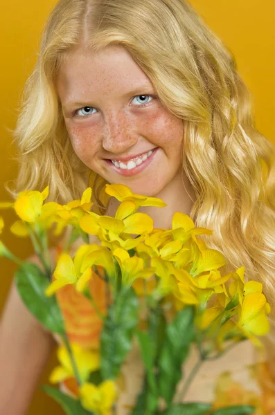 Blond meisje permanent in een tuin met handen geklemd, kijken — Stockfoto