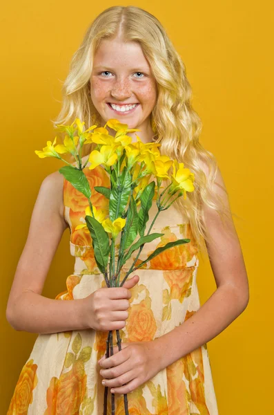 Blonde girl standing in a garden with hands clasped, looking at — Stock Photo, Image