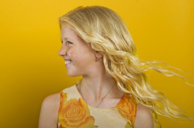 Beautiful blonde girl on a yellow background clipart