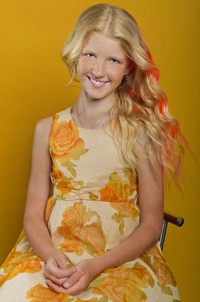 Prachtige blond meisje op een gele achtergrond — Stockfoto