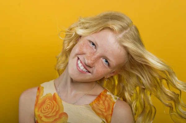 Prachtige blond meisje op een gele achtergrond — Stockfoto